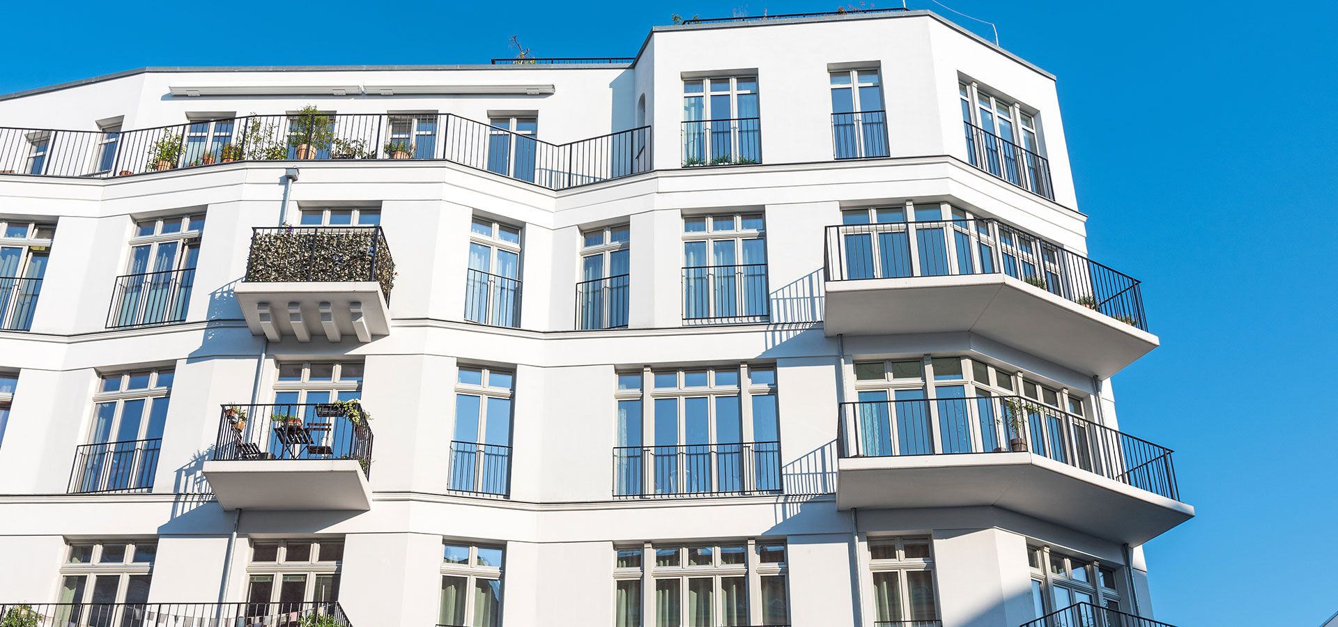 Helles Wohngebäude mit Verzierungen über den Fenstern